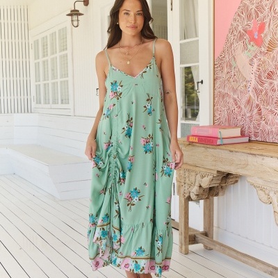 Vestido comprido verde com padrão floral usado por mulher