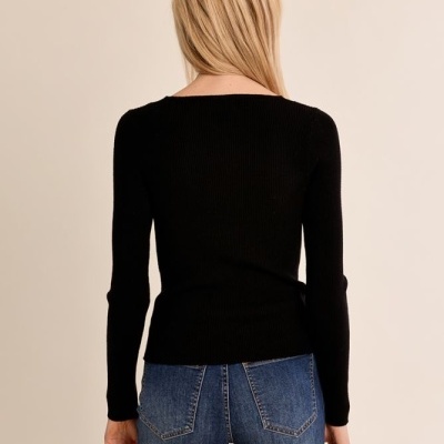 Mulher de costas com camisola preta e jeans azul