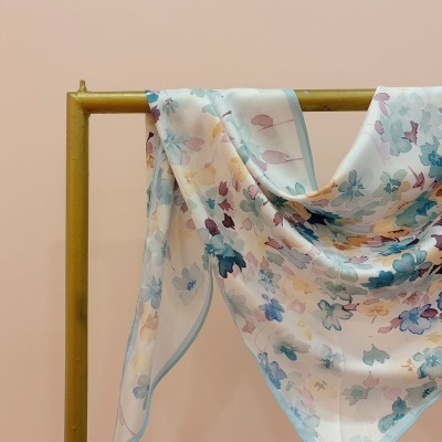 Lenço floral colorido pendurado num suporte dourado