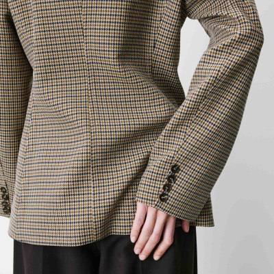 Blazer pied-de-poule bege com botões escuros e calças pretas