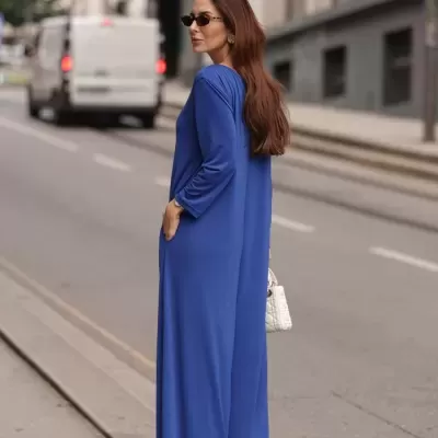 Vestido longo azul de manga comprida com corte reto, mulher vista de costas numa rua