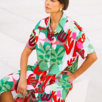 Vestido camisola colorido com padrão abstrato de folhas em várias cores e botões brancos.