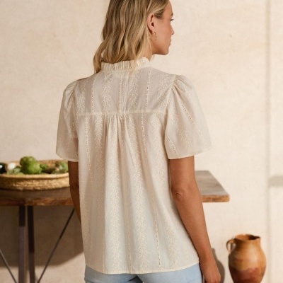 Blusa creme com padrão de furos e mangas curtas vista de costas