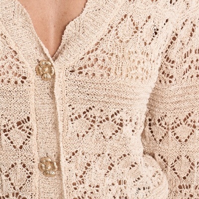 Casaco de malha bege com padrão de tricô em renda e botões dourados em forma de flor