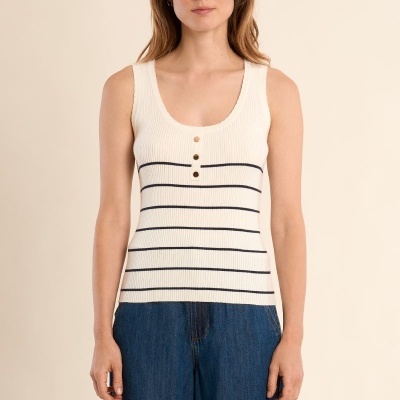 Top branco canelado com botões e riscas pretas usado com calças de ganga azuis.