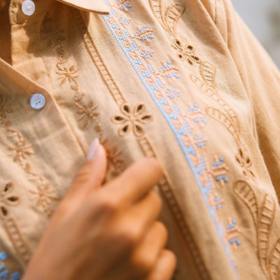 Blusa bege de algodão bordada com botões brancos e bordados florais em azul e bege