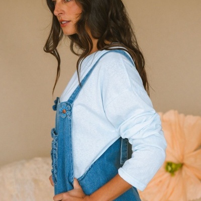 Mulher a usar macacão de ganga azul claro com t-shirt branca