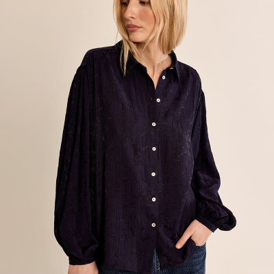 Camisa azul escura feminina com padrão floral e botões brancos, usada com jeans