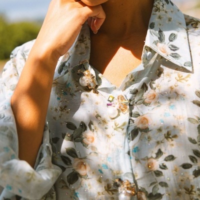 Blusa feminina floral com detalhes de pedraria e botões decorativos