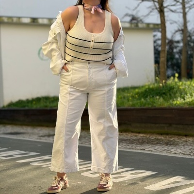 Mulher com roupa casual branca e sapatilhas cor de rosa ao ar livre