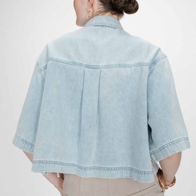 Casaco curto de ganga azul claro com mangas curtas visto de costas