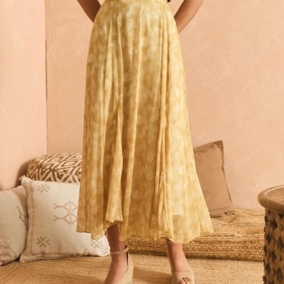 Saia comprida amarela com padrão floral e sandálias de cunha