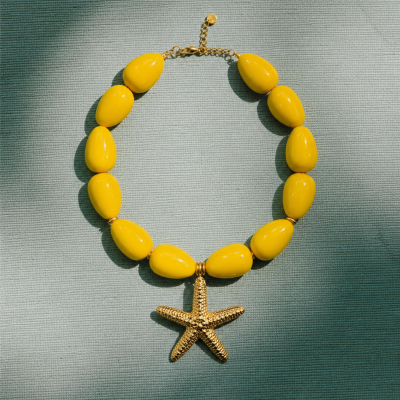 Colar com contas amarelas e pendente estrela do mar dourada