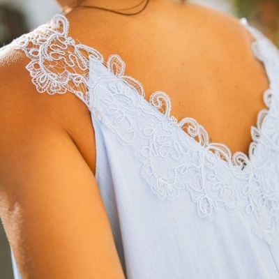 Vestido azul claro com renda branca nas alças, visto de costas
