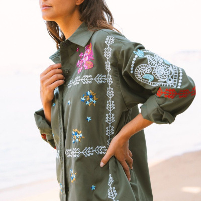 Camisa verde com bordados coloridos e padrões florais e geométricos
