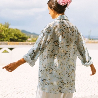Blusa floral leve com mangas compridas e flor rosa no cabelo