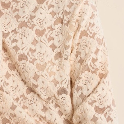 Blusa feminina de renda bege clara com padrão floral e gola alta