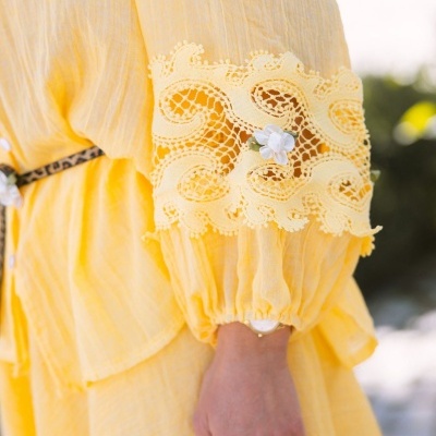 Manga de vestido amarelo com renda e flor branca