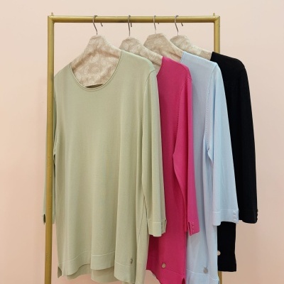 Quatro camisolas coloridas de manga comprida penduradas num cabide