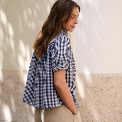 Blusa xadrez preto e branco com gola alta e calças bege