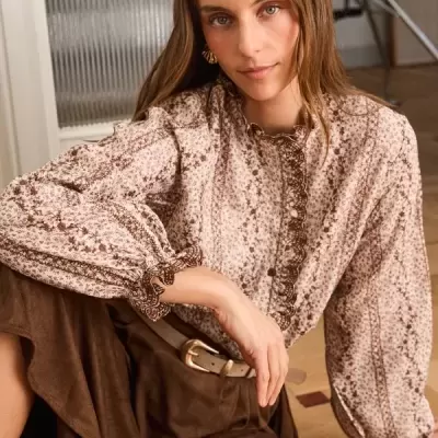 Blusa floral bege e castanha de mangas compridas com saia castanha e cinto bege