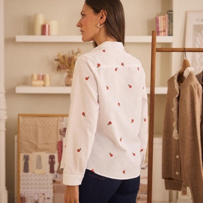 Camisa branca com flores vermelhas e amarelas vista de costas