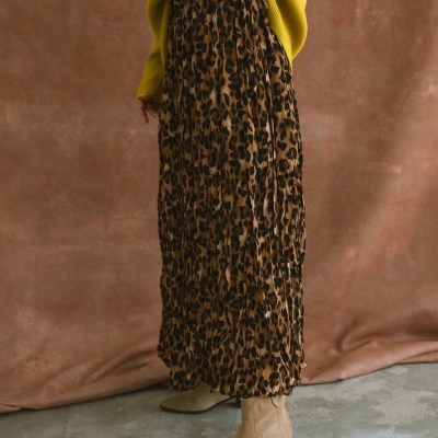 saia comprida plissada com padrão animal print, botins bege e suéter amarelo mostarda