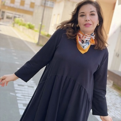 Mulher a usar vestido preto comprido e lenço colorido com padrão floral