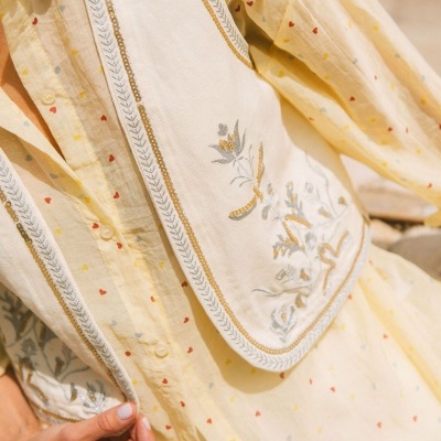 Camisa amarela clara com pequenos corações coloridos e bordado floral prateado e dourado