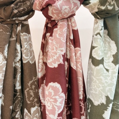 Três lenços florais castanhos, rosa e verde pendurados