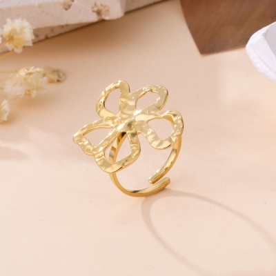 Anel dourado em forma de flor com pétalas abertas.