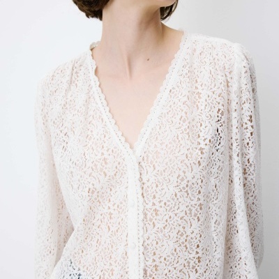 Blusa feminina branca de renda com padrão floral e decote em V.