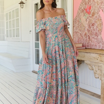 Vestido longo feminino ombro a ombro com padrão floral colorido e sandálias pretas