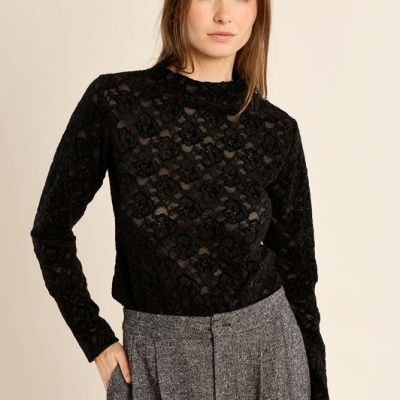 Blusa preta de renda floral e calças cinzentas texturizadas