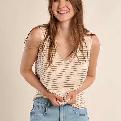 Mulher sorridente com regata de riscas e calças de ganga azuis claras