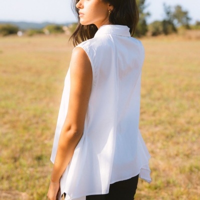 Blusa branca sem mangas com gola usada por mulher em campo aberto