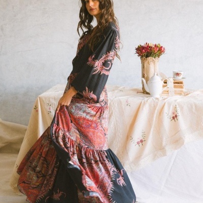 Vestido comprido florido em ambiente rústico com mesa e flores