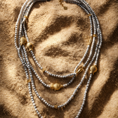Colar com contas cinza e detalhes dourados em areia