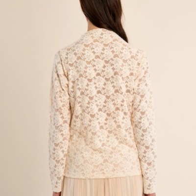 Blusa de renda creme com padrão floral vista pelas costas