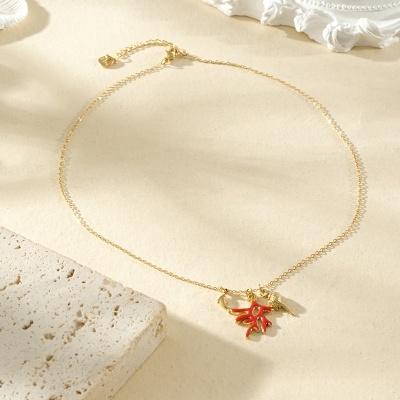 Colar dourado com pendentes de coral vermelho e concha dourada