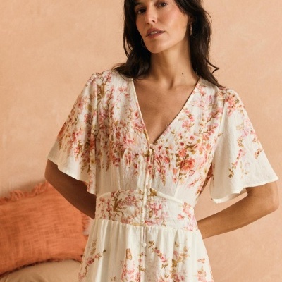 Vestido branco com padrão floral em rosa e bege, mangas largas e botões frontais