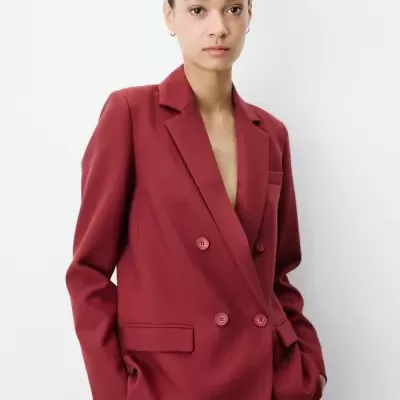 Blazer vermelho de duplo abotoamento com lapelas e bolsos usado por modelo