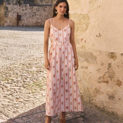 Vestido comprido de mulher listrado e com padrão floral, sandálias castanhas com plataforma