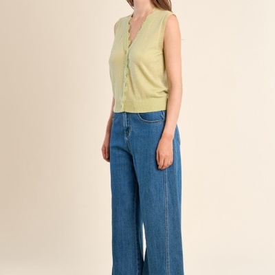 Mulher a usar colete verde claro e jeans azul