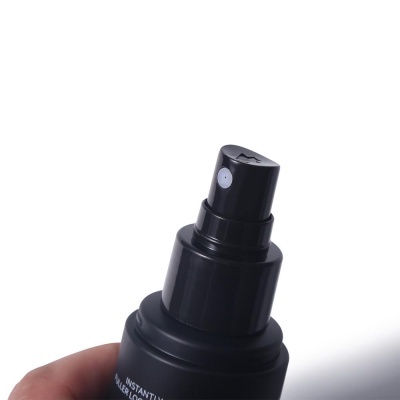 Frasco de spray preto fosco com bico pulverizador segurado por uma mão