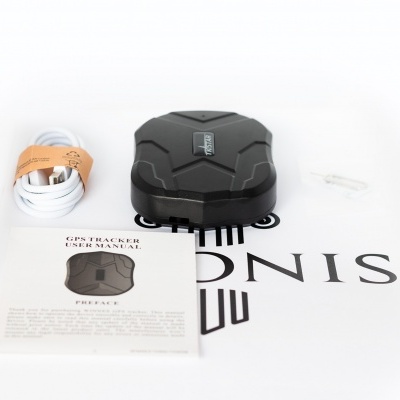 Rastreador GPS preto, cabo USB branco e manual de utilizador num fundo branco