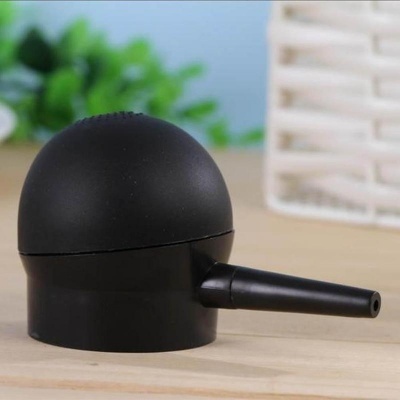 Dispositivo preto fosco arredondado com bico tubular em cima de madeira clara