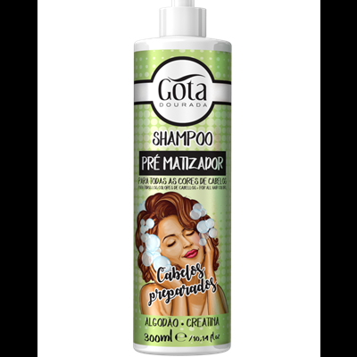 Frasco de shampoo Gota Dourada com rótulo verde e imagem de mulher com espuma no cabelo