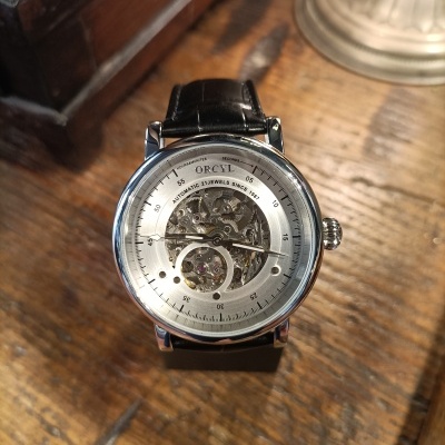 Relógio ORCYL com bracelete de couro preto e mostrador com mecanismo visível