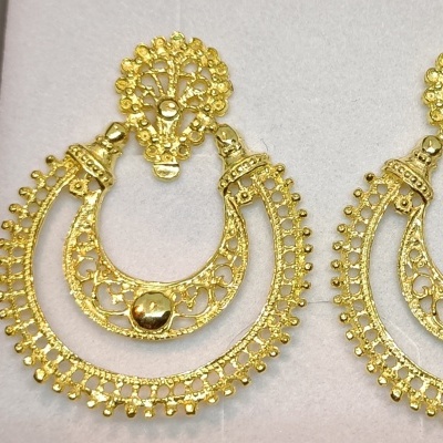 Brincos dourados com filigrana e esferas sobre fundo branco